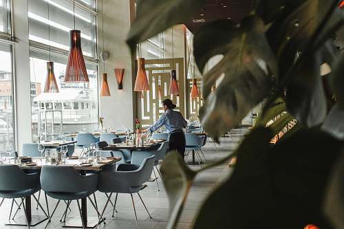 furniture woman in front on brown dining table and chairs inside building restaurant