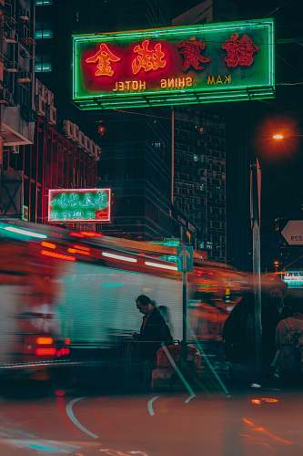urban man wearing black jacket walking on street during nighttime metropolis