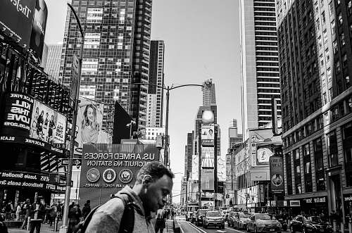human person walking in road during daytime black-and-white