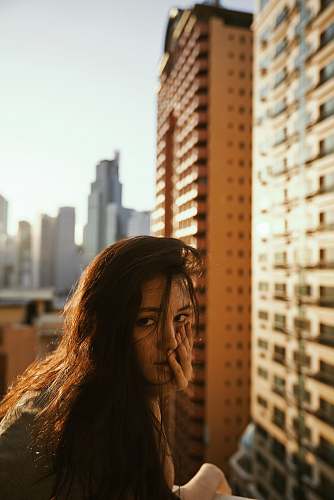 building woman in gray top beside building urban