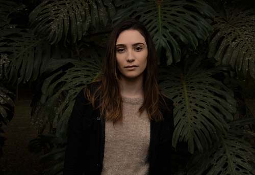 apparel woman standing in front of green leafed plants human