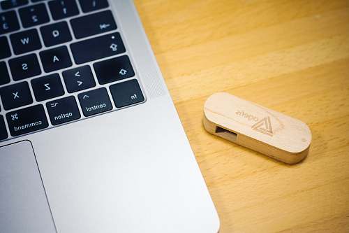 hardware brown thumb drive beside MacBook computer keyboard