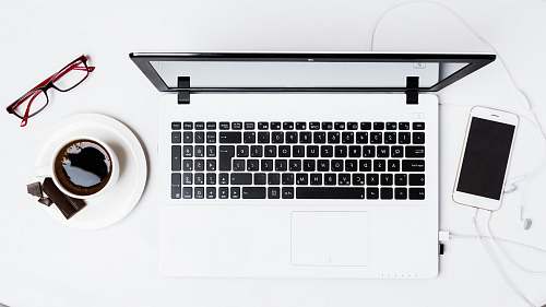 phone MacBook Pro between smartphone and teacup on white surface drink