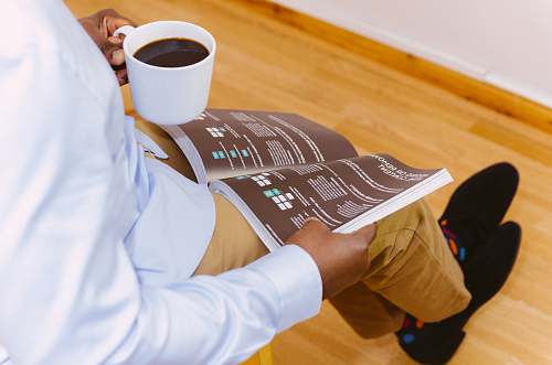 drink man holding coffee mug and reading magazine beverage