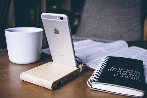 book silver iPhone 6 beside white ceramic mug warsaw