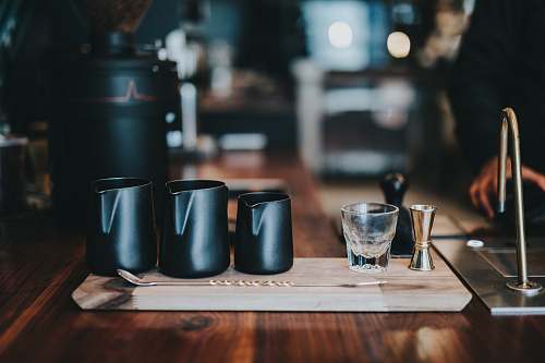 glass three black milk jars on brown table table