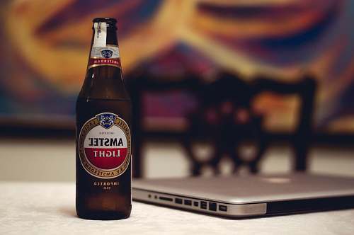 alcohol Amstel Light beer bottle near laptop computer beer