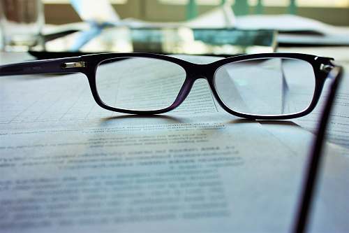 reading black-framed eyeglasses on white printing paper book
