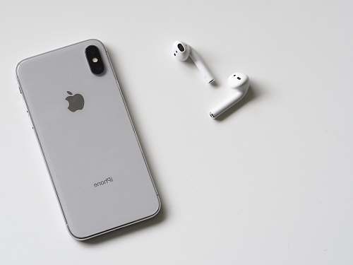 black-and-white silver iPhone X and Apple EarPods phone