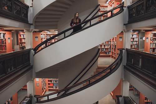 finland woman standing on spiral stairway library