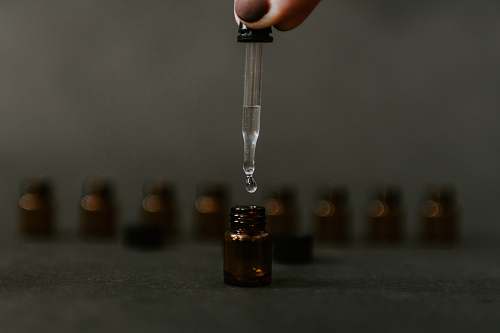 person clear drop bottle
