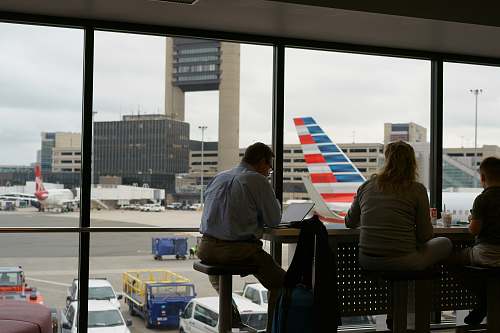 person man and woman sitting on chair inside airport people