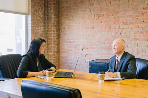 person man and woman talking inside office sitting