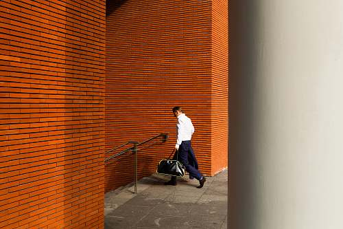 person man holding duffel bag down stair people