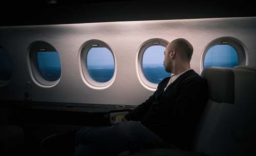 person man seating near window window