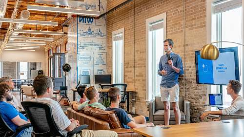 person man standing in front of group of men furniture