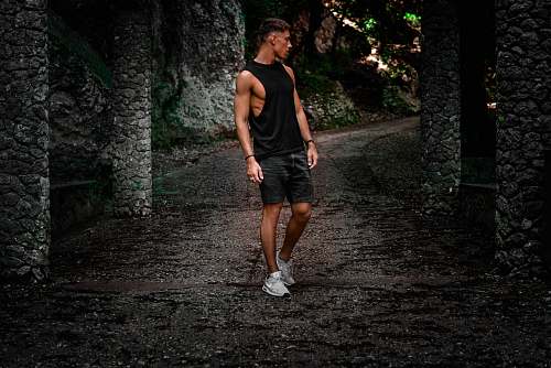 people man standing on pathway between concrete post person
