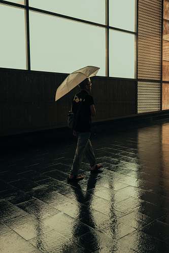 person man walking while holding umbrella kuala lumpur