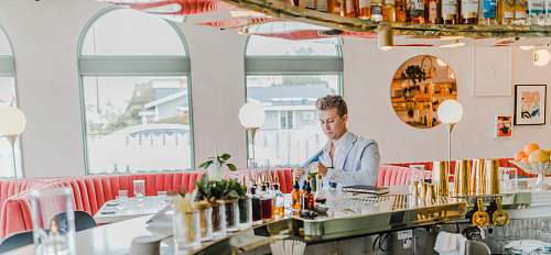 person man wearing gray suit standing beside counter restaurant