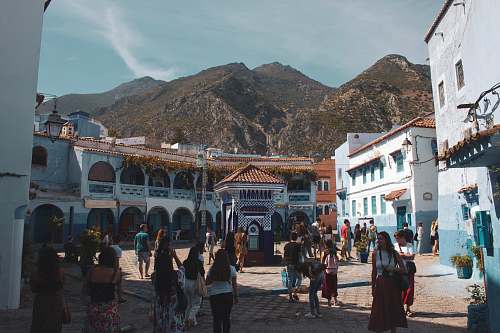 pedestrian people surrounded by blue concrete houses person