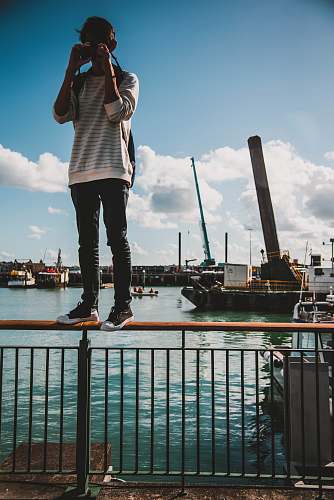 banister person standing railing during daytime handrail