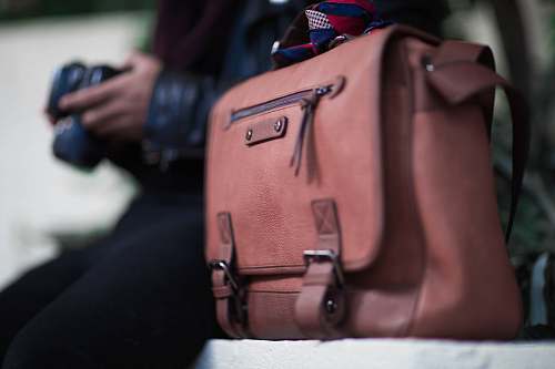 person selective focus photogrtaphy of brown leather crossbody bag people
