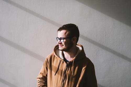 people smiling man standing near wall during daytime person
