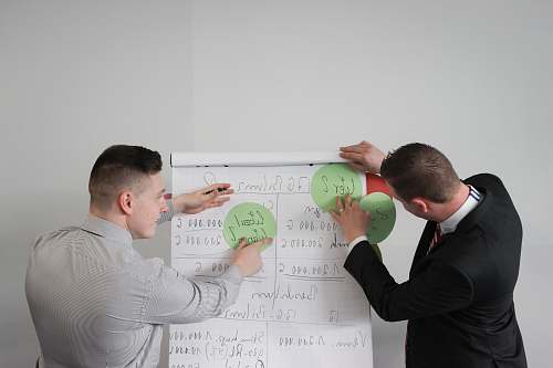 person two men doing presentation visual aide white board