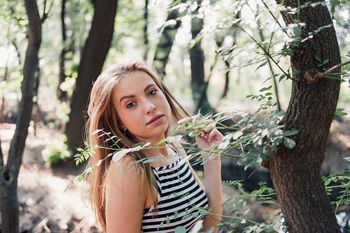 person woman in black and white striped top standing beside tree people