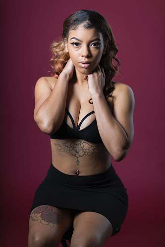 person woman in black bra and black mini skirt sitting on bar stool clothing