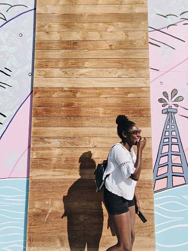 person woman standing behind brown wall people