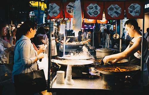 person woman standing in front of food stall clothing