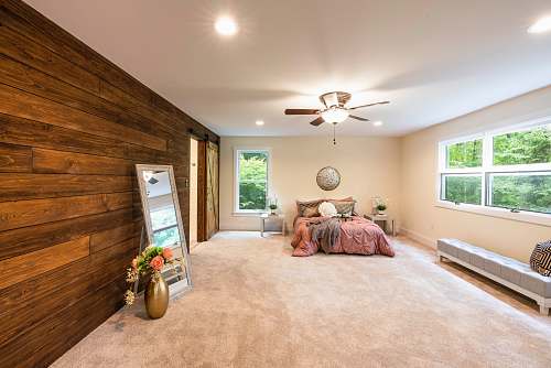 appliance empty bedroom with turned-on lights ceiling fan