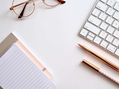 computer pen near black lined paper and eyeglasses electronics
