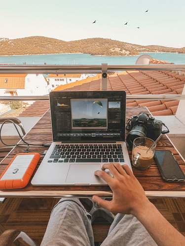 electronics person holding MacBook Pro besides orange power bank hardware