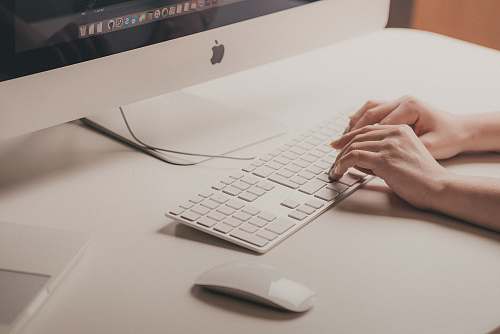 work person typing on Apple keyboard hands