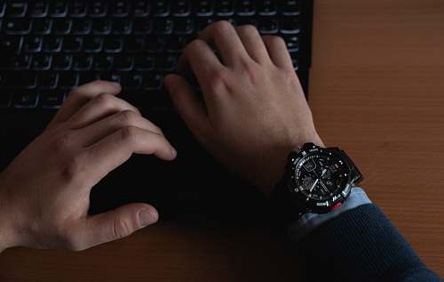 wristwatch person using black computer keyboard computer