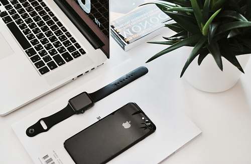 work space black stainless steel Apple Watch on table beside the MacBook Pro desk