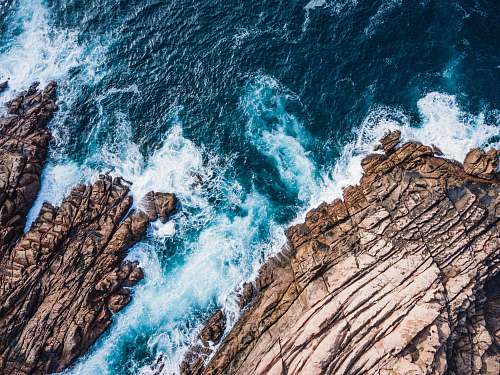 ocean aerial photo of rock formation beside body of water sea