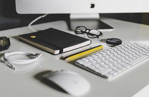 desk Apple Magic Keyboard and Apple Magic Mouse on white table workspace