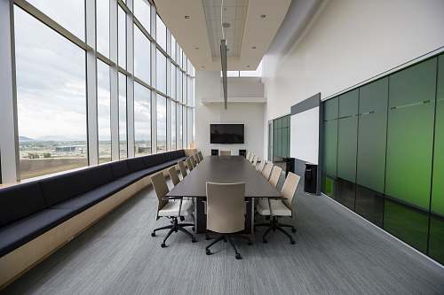 room rectangular brown wooden table with chair lot inside building meeting room