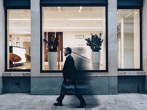 person man in black suit jacket in walking gesture window