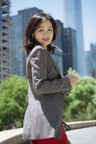 human smiling woman wearing red, black, and gray plaid blazer person
