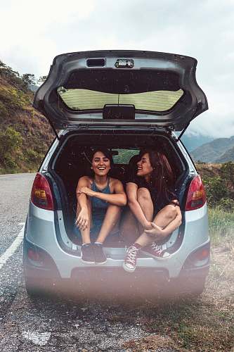 human two women in hatchback compartment person