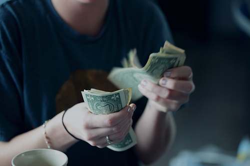 people focus photography of person counting dollar banknotes human
