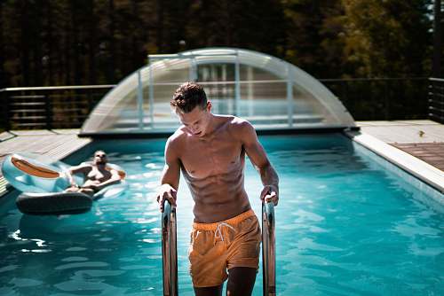 human man holding grey steel swimming pool ladder people