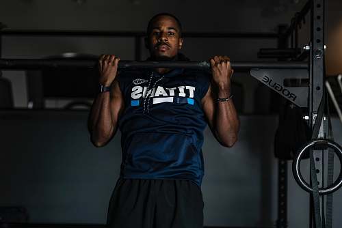 human man lifting up gym equipment working out