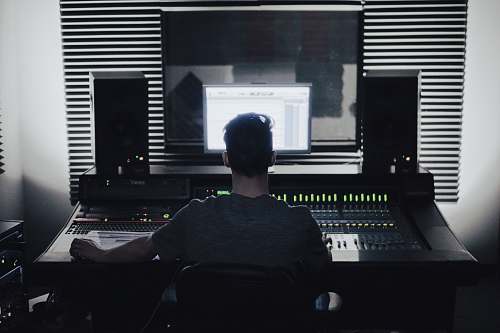 human man sitting in front of computer setup studio