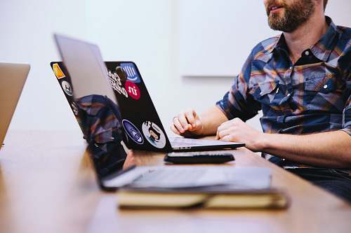 human man sitting in front of laptop people