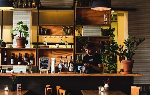 human man standing in front of bar table pub
